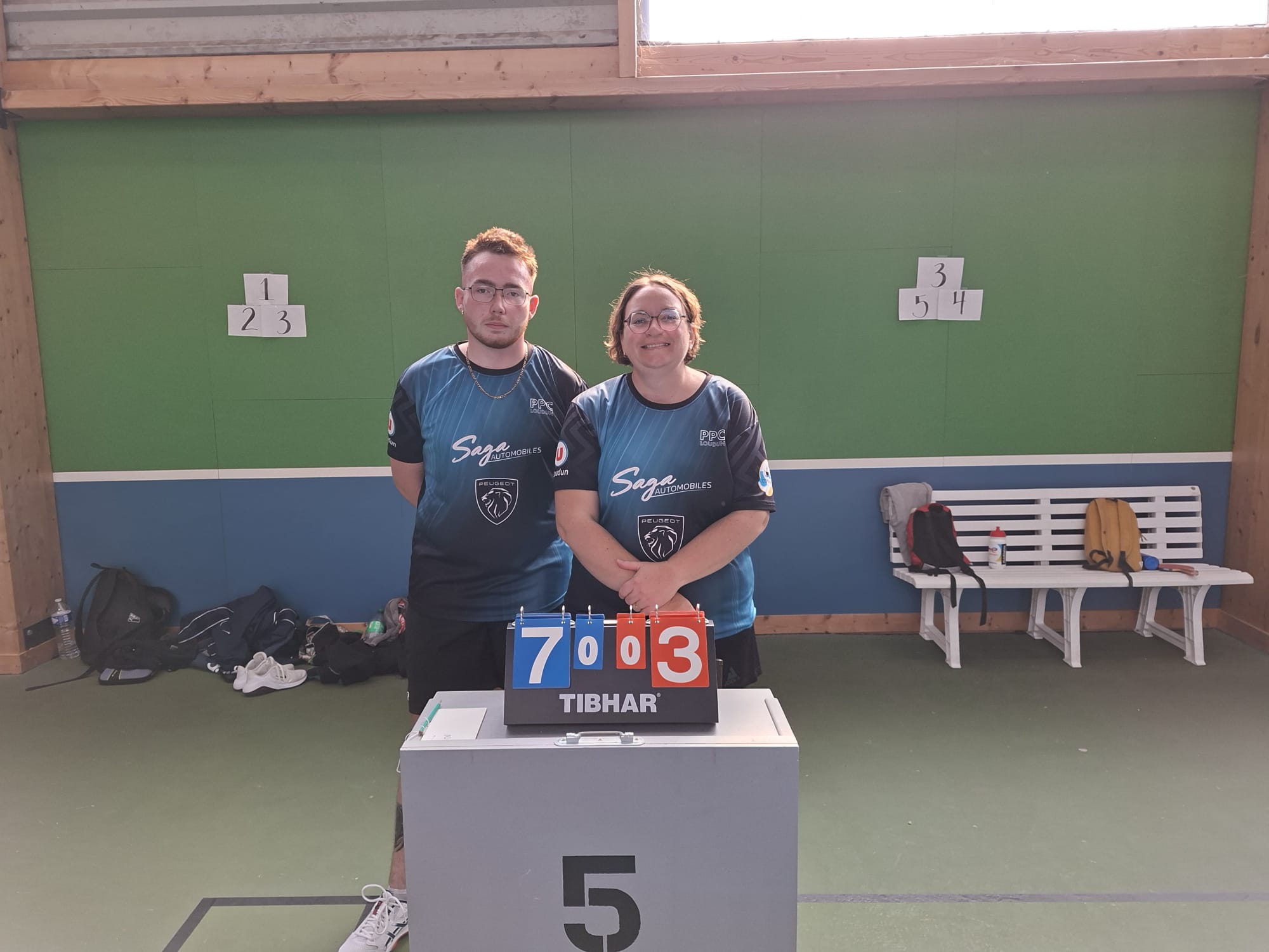 Deux joueurs de Loudun 3 devant le tableau de score affichant la victoire 7 à 3