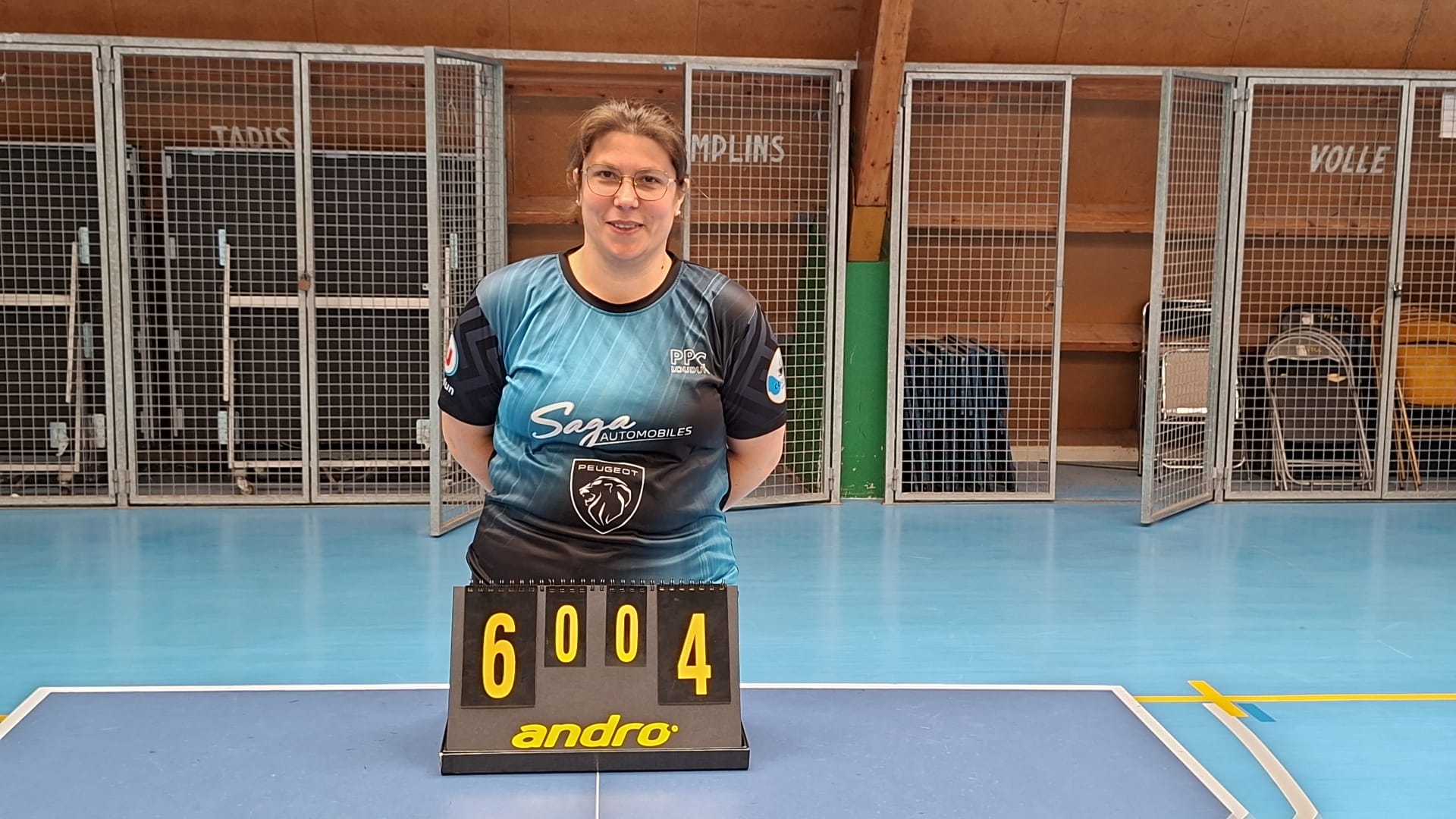 Une joueuse de Loudun 3 derrière le tableau de score affichant la victoire 6 à 4